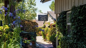 Kapea polku johtaa rakennukseen, jonka yläpuolella on kyltti, jossa lukee: ”Carmel Fireplace Inn”.