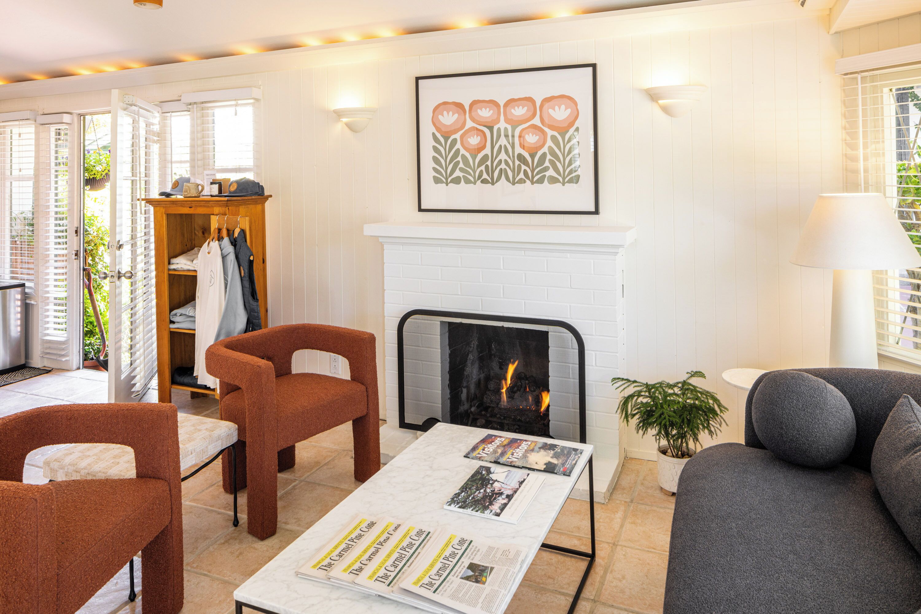 A cozy living room with a fireplace, a coffee table with magazines, and a sofa.