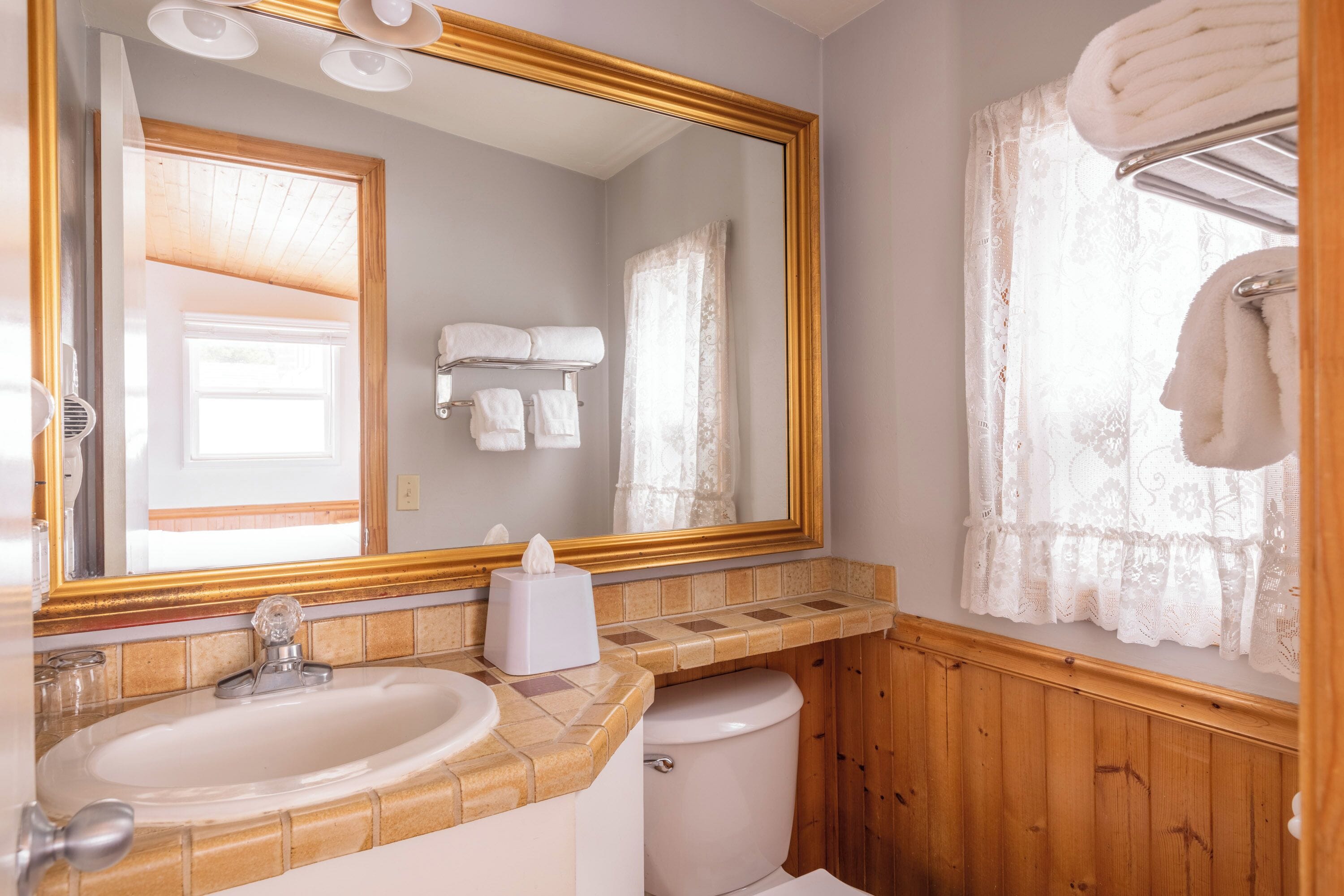 A bathroom with a sink, mirror, and toilet.