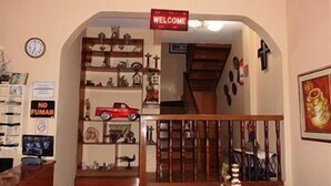 A cozy interior with a wooden staircase, a 'Welcome' sign, a 'No Fun' sign, and various decorative items on shelves. - Hotel Francisco I (Salinas)