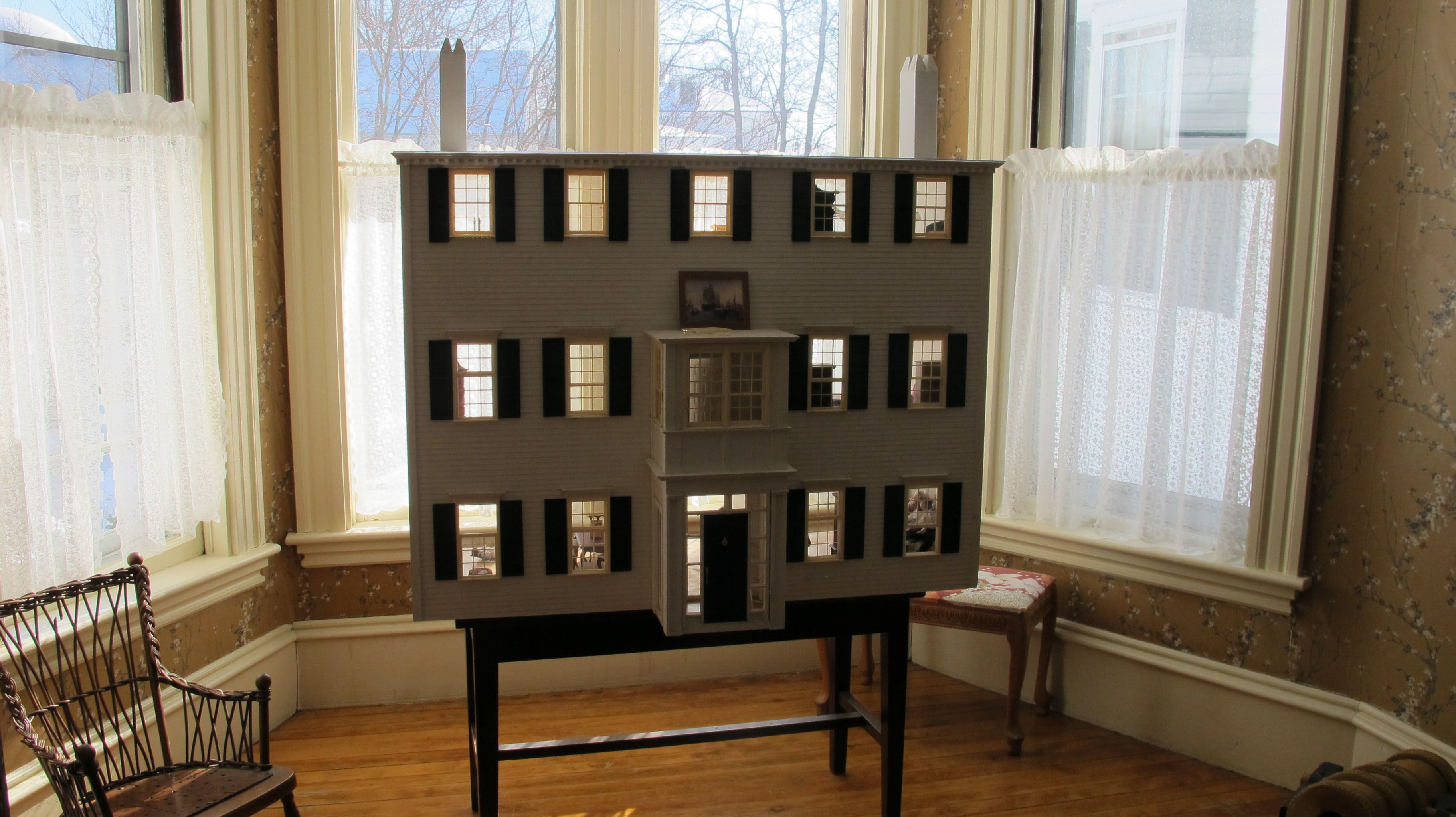 A model of a multi-story building with multiple windows and a central staircase.