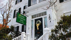 Un bâtiment blanc avec une enseigne verte indiquant « Clark Currie Inn ».