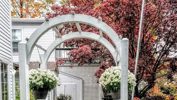 Un chemin pavé de briques mène à une porte d’entrée blanche sur laquelle est apposée une plaque indiquant « ENTRÉE ».