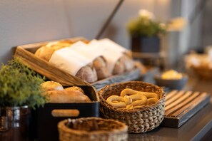 A buffet table with various breads and pastries.