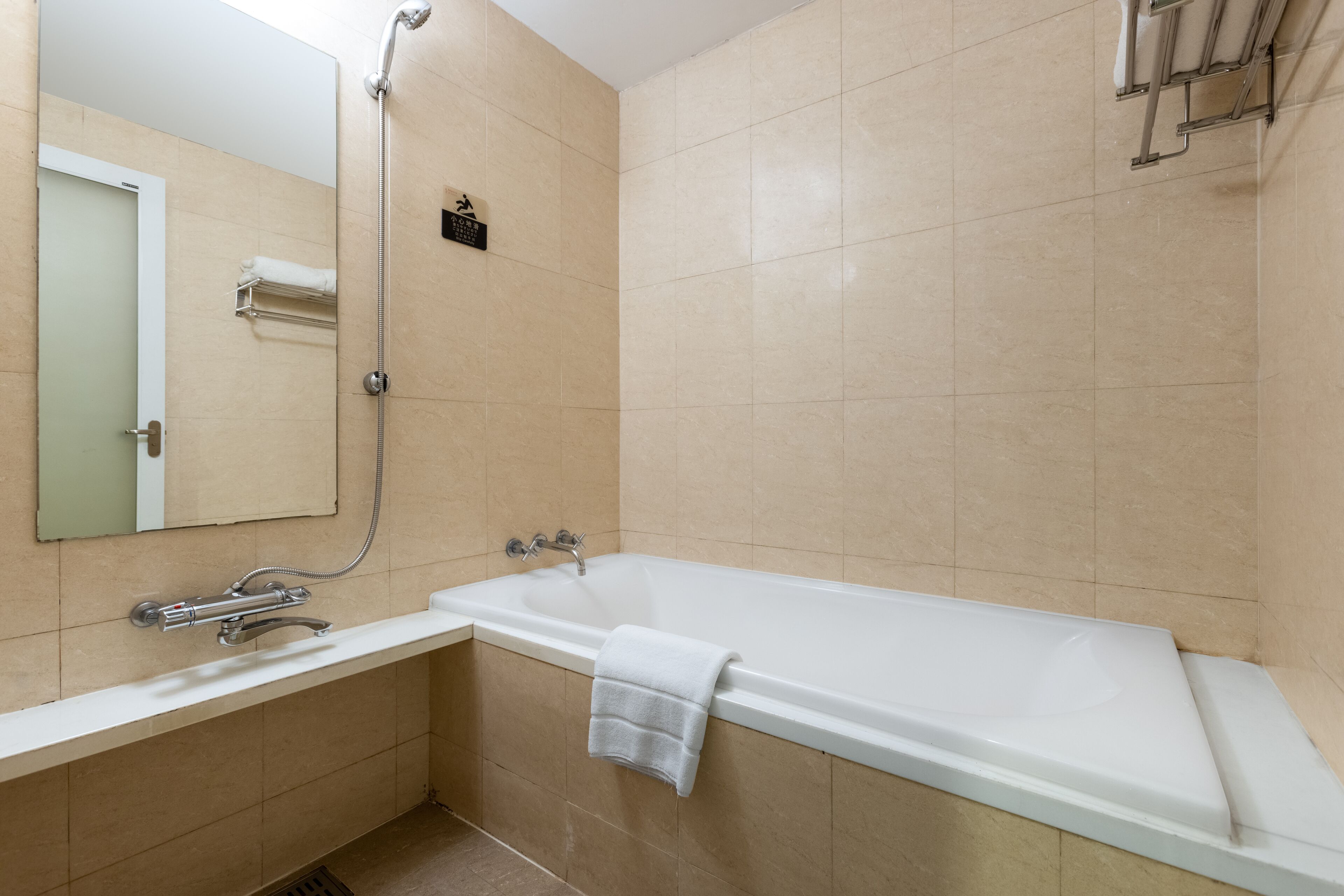 A modern bathroom with a bathtub, a shower, and a sink.