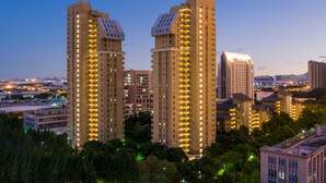 Un ensemble d’immeubles de grande hauteur, dotés de nombreux étages et de balcons, entouré d’arbres et d’autres bâtiments.