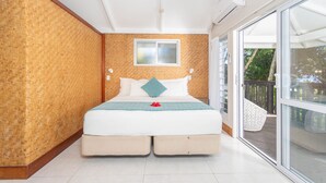 A bedroom with a large bed, a window, and a balcony. - Muri Lagoon View Bungalows (Rarotonga)