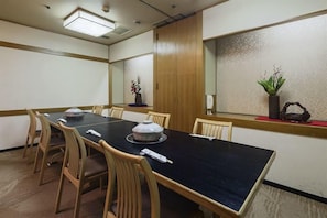 A conference room with a long table, wooden chairs, and a decorative vase on the windowsill. - Hotel Hokke Club Sendai (Sendai)