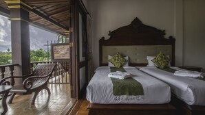 A bedroom with two beds, a balcony with a view, and a wooden ceiling. - The View Pavilion (Luang Prabang)