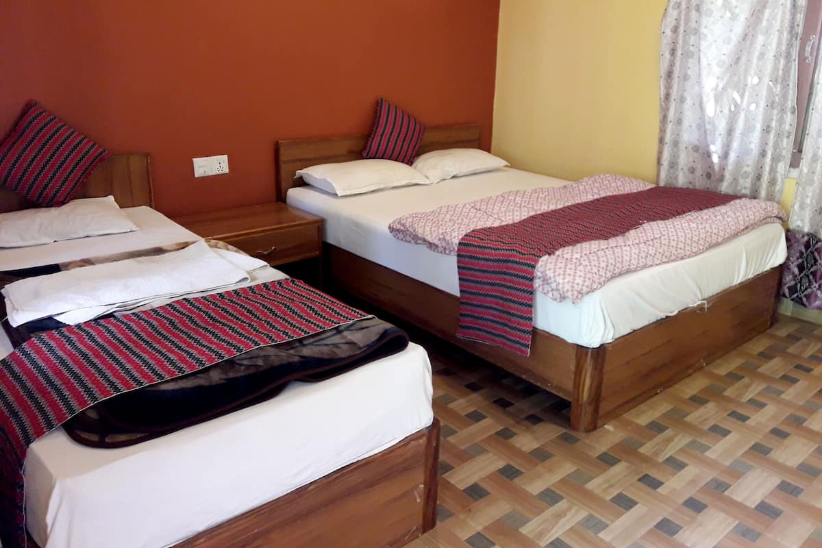 Hotellihuone, jossa on kaksi sänkyä, puiset päätyosat ja kuvioitu lattia.