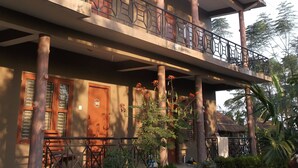 A multi-story building with balconies, a staircase, and potted plants. - Hotel Park Inn (Sauraha)