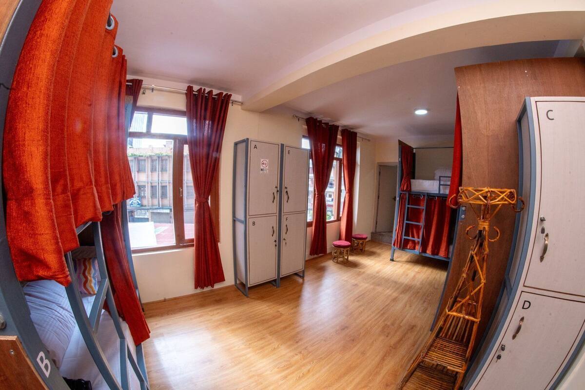 A compact room with a bunk bed, a wardrobe, and a small kitchenette.