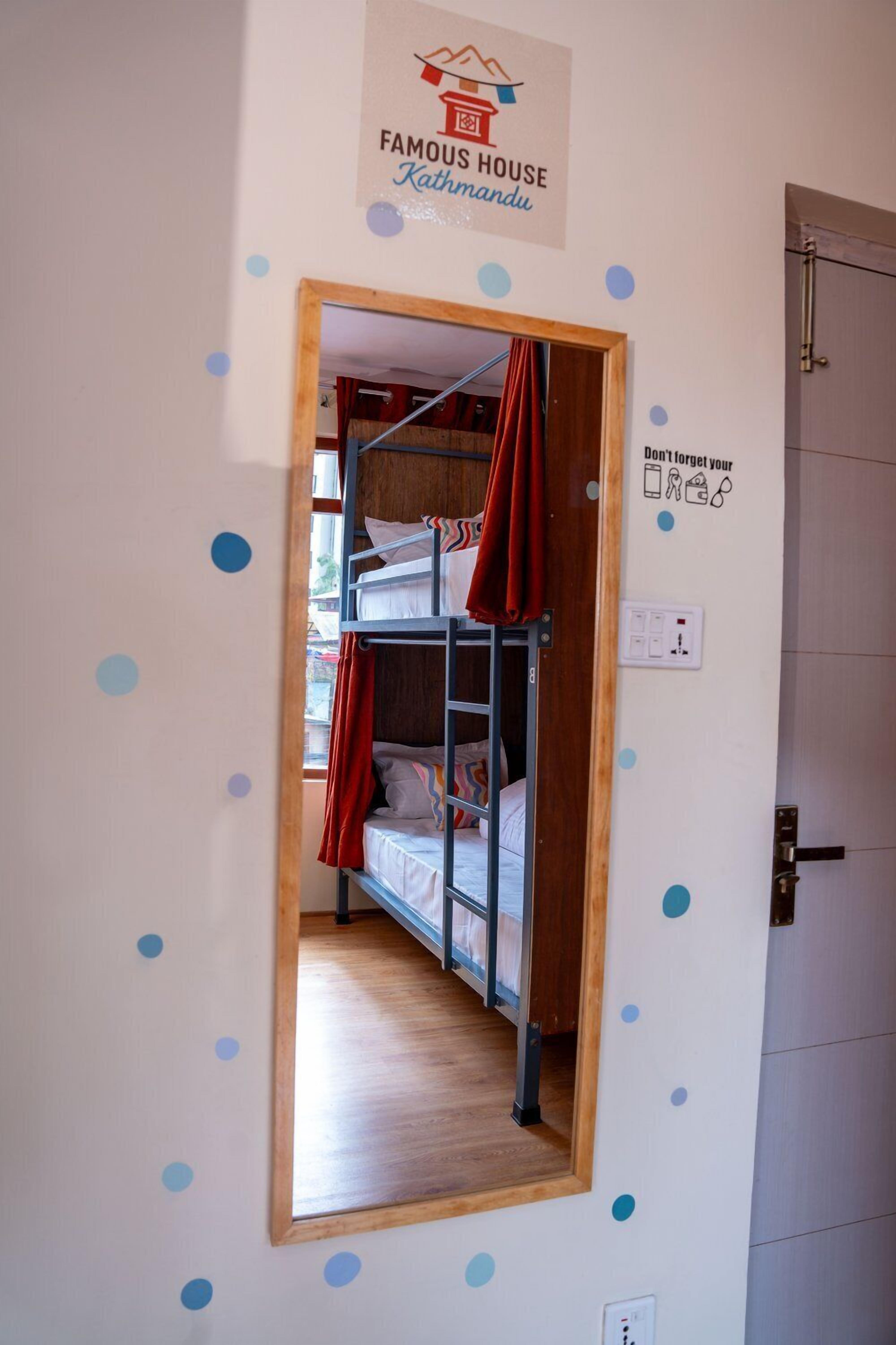 A bunk bed room with a mirror, a door with a sign, and a wall with a logo.