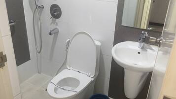 Un baño con inodoro, lavabo, bidé y espejo.