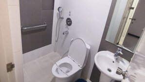 Een moderne badkamer met toilet, bidet en wastafel.