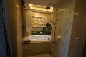 Un baño con bañera, ducha y un panel decorativo en la pared.