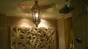 Un baño con una bañera independiente, ducha y un panel decorativo en la pared.