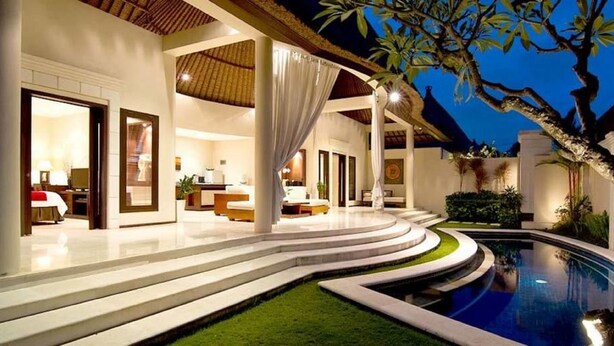 A modern resort with a swimming pool, outdoor seating, and a well-lit interior. - Arsa Villa Bali (Seminyak)