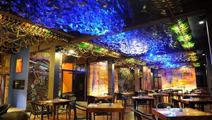 A restaurant with a ceiling made of colorful glass pieces, wooden tables, and chairs. - Pimann Buri Pool Villas Ao Nang Krabi - SHA Plus (Krabi)