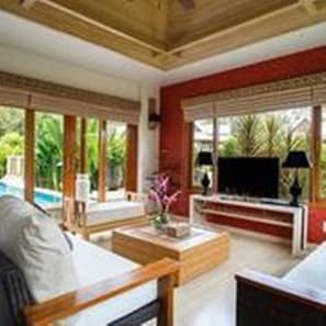 A room with a large window, a television, and a seating area with a table and chairs.