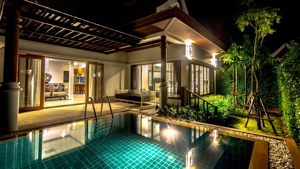 A swimming pool with a tiled deck, a covered patio area, and a view of a house with large windows and a garden. - Pimann Buri Pool Villas Ao Nang Krabi - SHA Plus (Krabi)