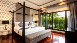 A four-poster bed with a grey bench, a TV, and a view of greenery through large windows. - Pimann Buri Pool Villas Ao Nang Krabi - SHA Plus (Krabi)