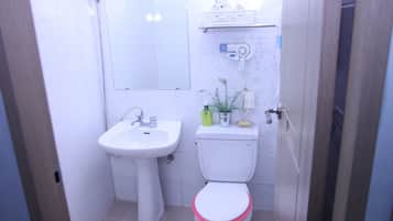 Ein kleines Badezimmer mit Waschbecken, Toilette und Spiegel.