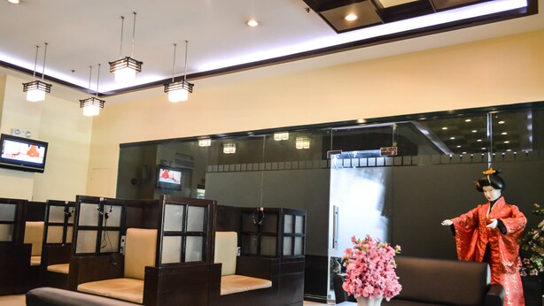 A traditional Japanese room with tatami mats, a television, and a decorative statue. - Hotel Sogo Recto (Manila)