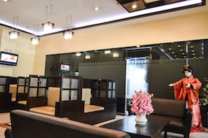 A traditional Japanese room with tatami mats, a television, and a decorative statue. - Hotel Sogo Recto (Manila)