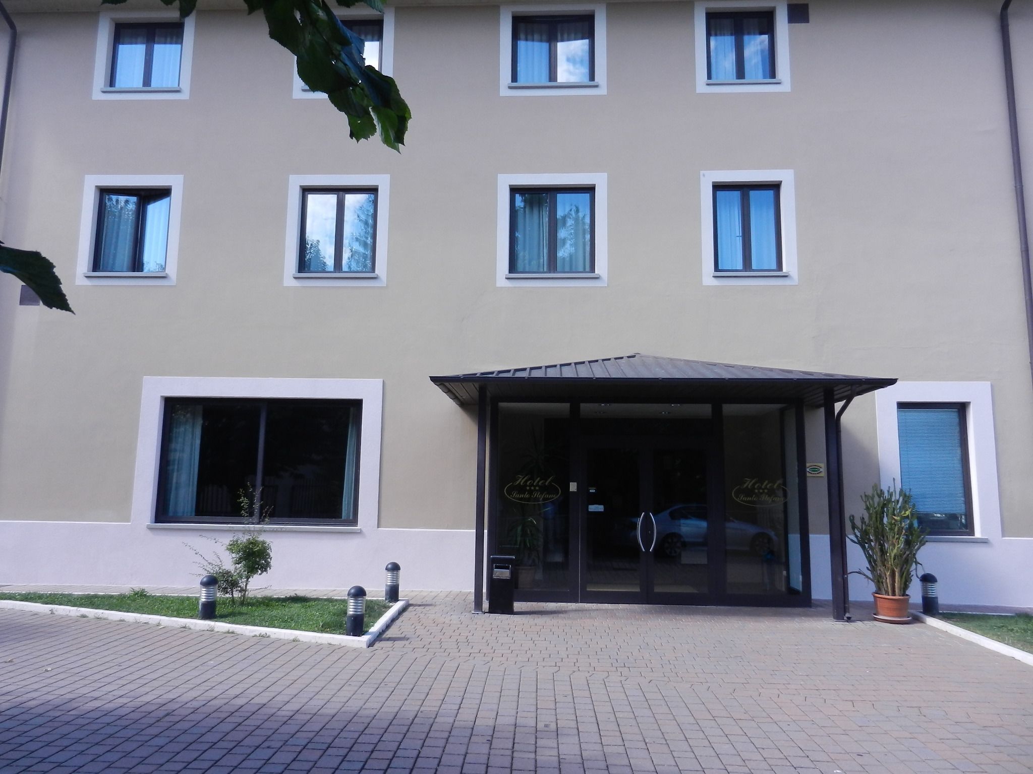 Un hotel amb una façana moderna, nombroses finestres i un vestíbul cobert.