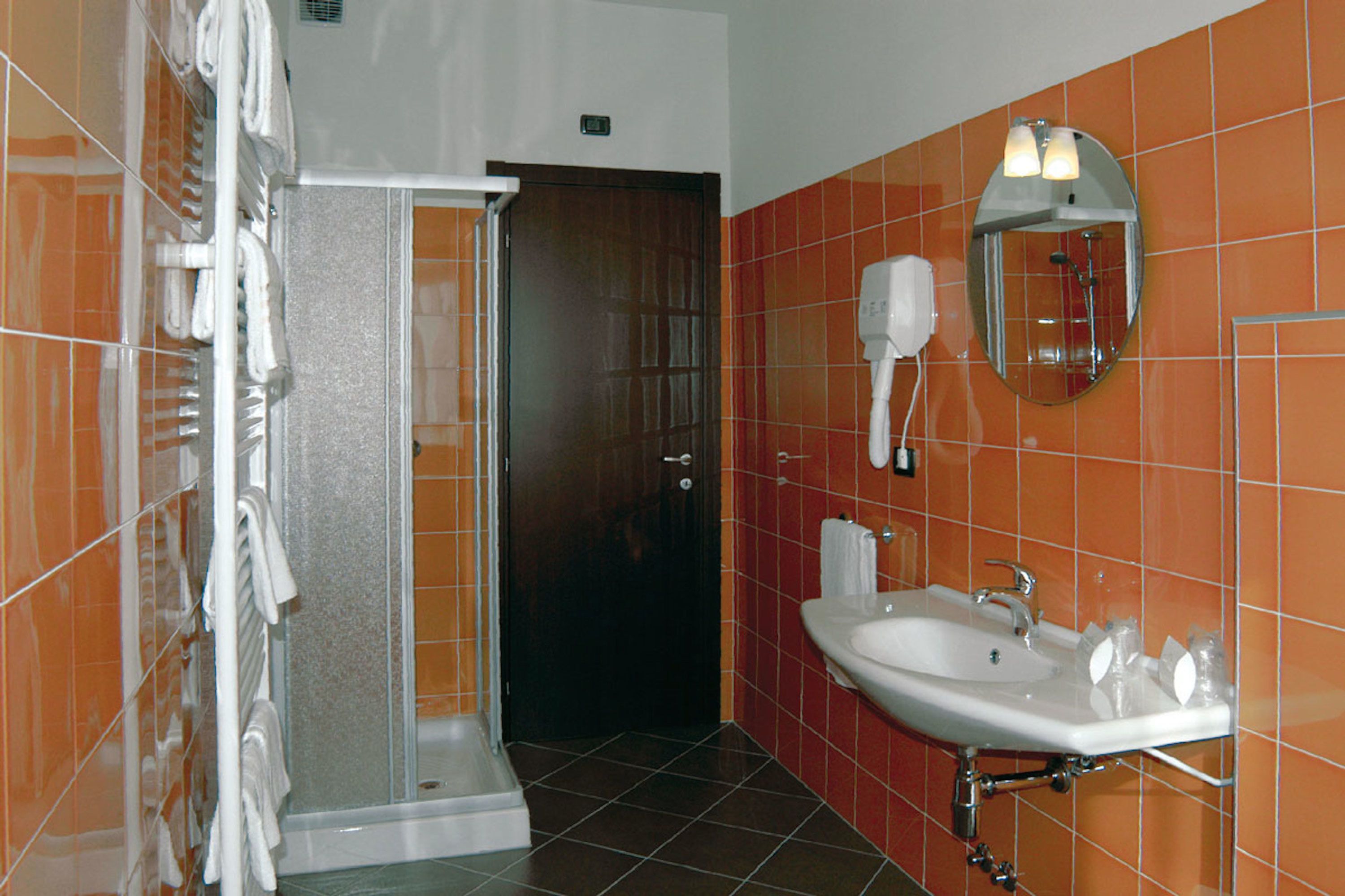 Ein Badezimmer mit Dusche, Waschbecken und Handtuchhalter.