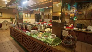 A buffet setup with multiple food stations and serving utensils. - Seri Malaysia Bagan Lalang (Sungai Pelek)