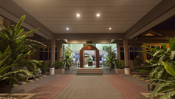A hotel entrance with a central archway, potted plants, and a tiled pathway leading to the entrance. - Seri Malaysia Bagan Lalang (Sungai Pelek)