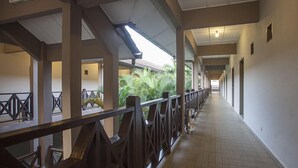 A covered corridor with a tiled floor, metal railings, and a view of greenery outside. - Seri Malaysia Bagan Lalang (Sungai Pelek)