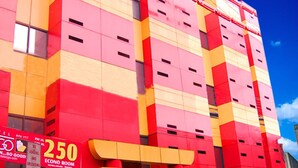 Een hotel met een gevel in rood en geel, een bordje met '250 Econo Room' en een Modern bord.