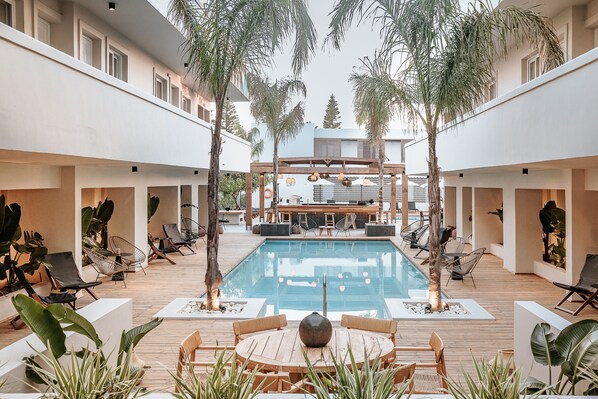 Una piscina al aire libre de temporada, sombrillas