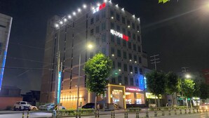 A multi-story hotel with illuminated signage, a visible restaurant, and a parking area. - Benikea Hotel Pohang (Pohang)
