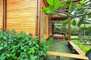 A wooden building with a garden pathway leading to a wooden bench. - Viangviman Private Pool Villa and resort (Krabi)