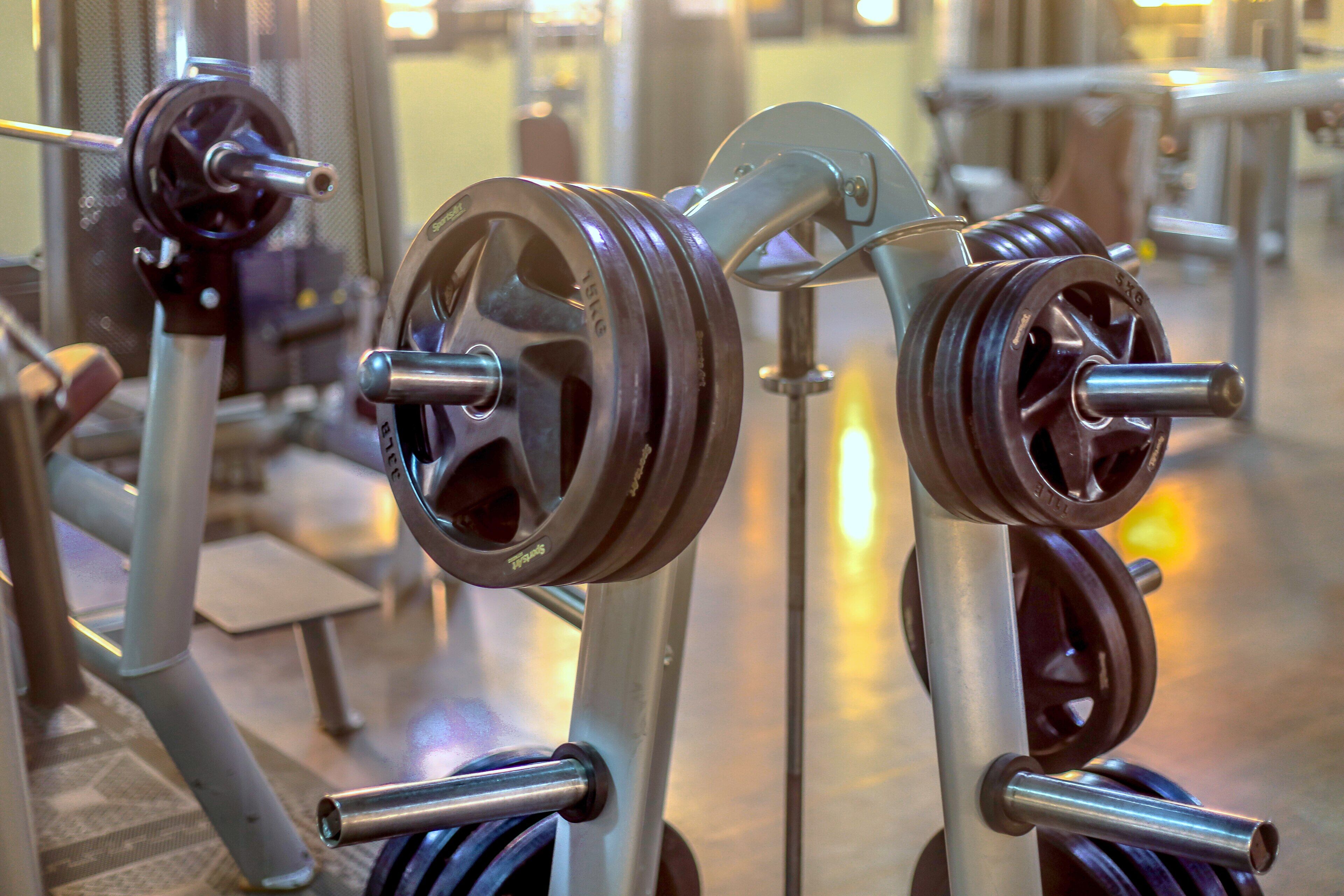 A gym with weightlifting equipment, including barbells and weight plates.