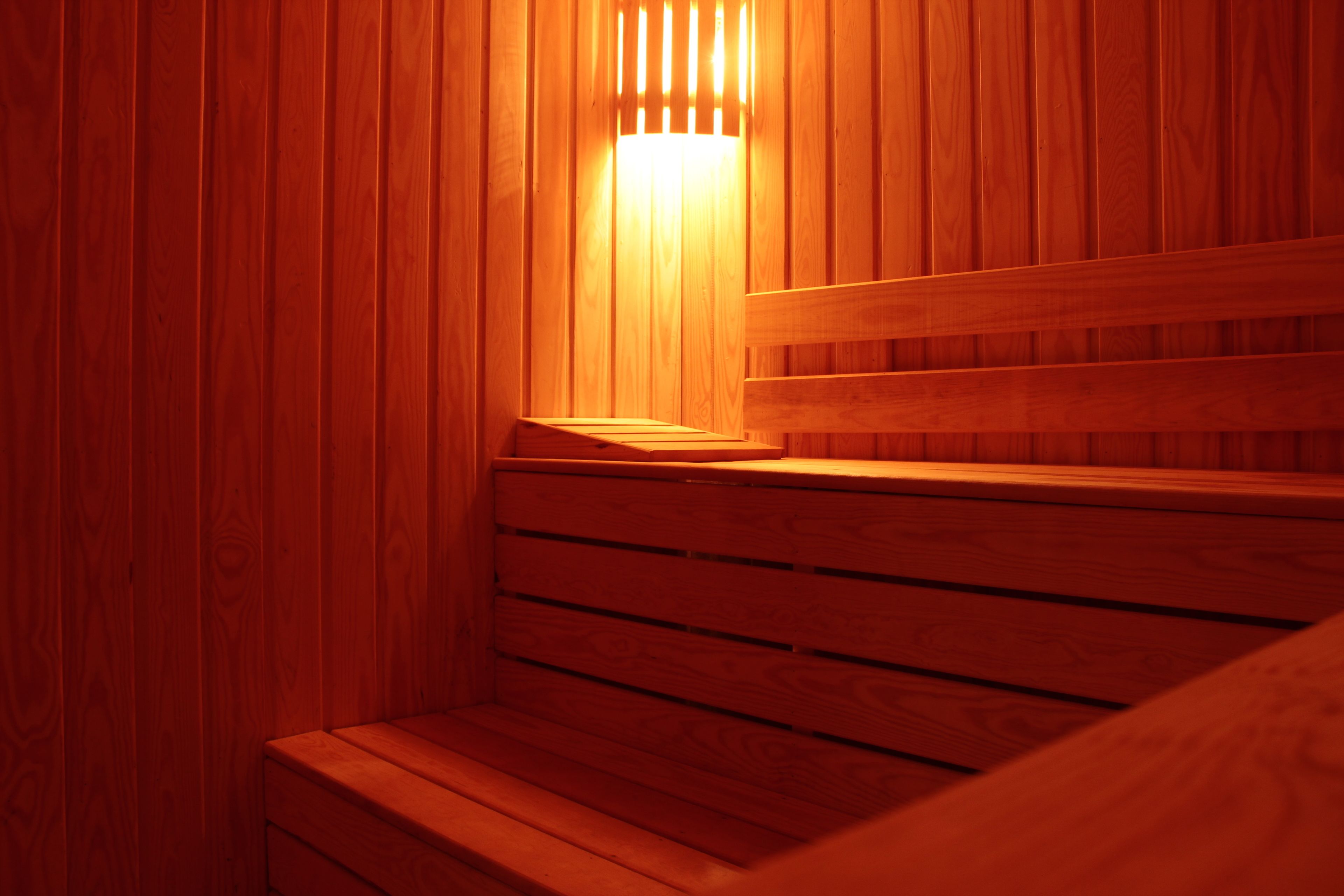 Una sauna de madera con un banco y una lámpara.