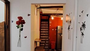 A hallway with a wooden floor, a staircase, and a door with a butterfly decal. - Exclusive Dependance (Palermo)