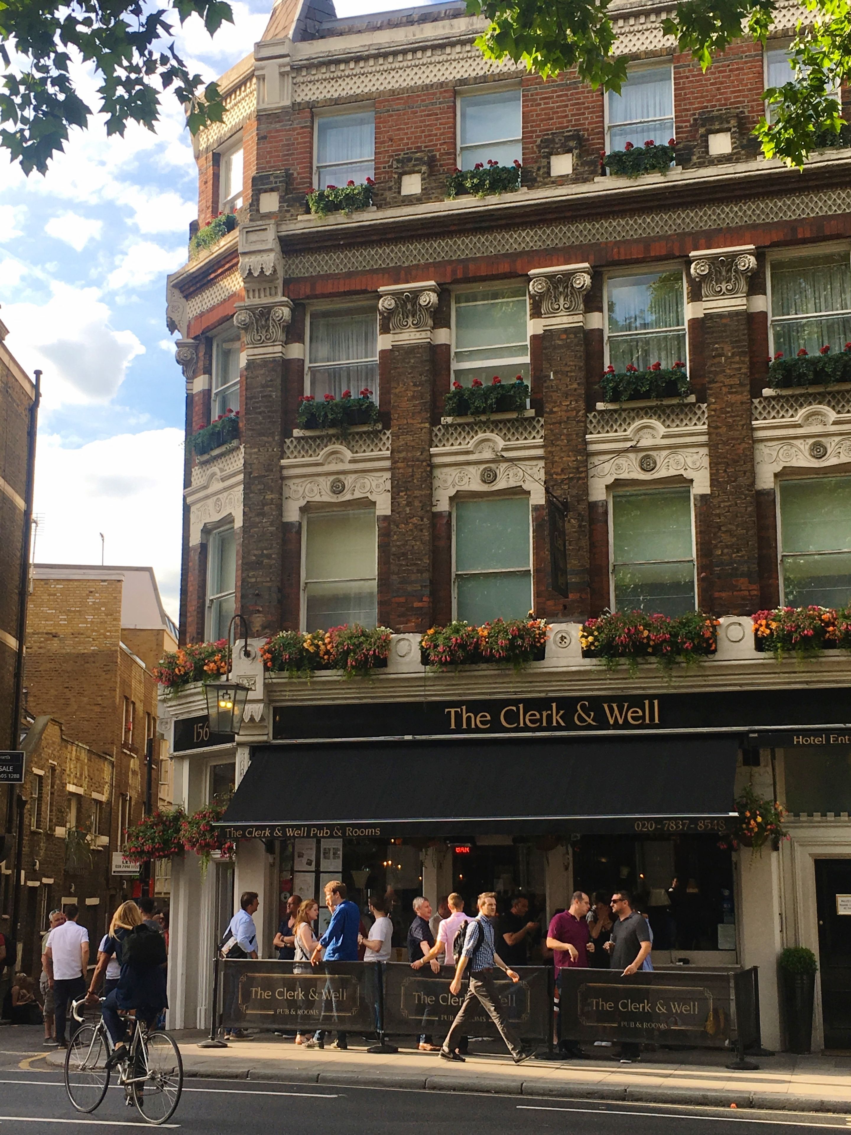A historic building with a pub named "The Clerk & Well" on the ground floor.