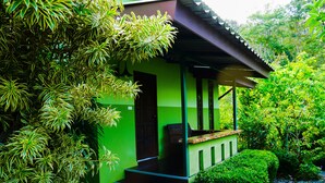 Una casita verde con un porche y escalones que conducen a una puerta.