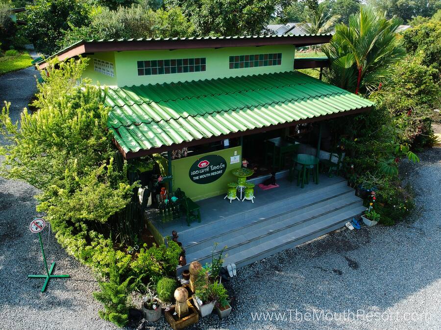 A small, single-story building with a green roof and a sign that reads "The Mouth Resort."