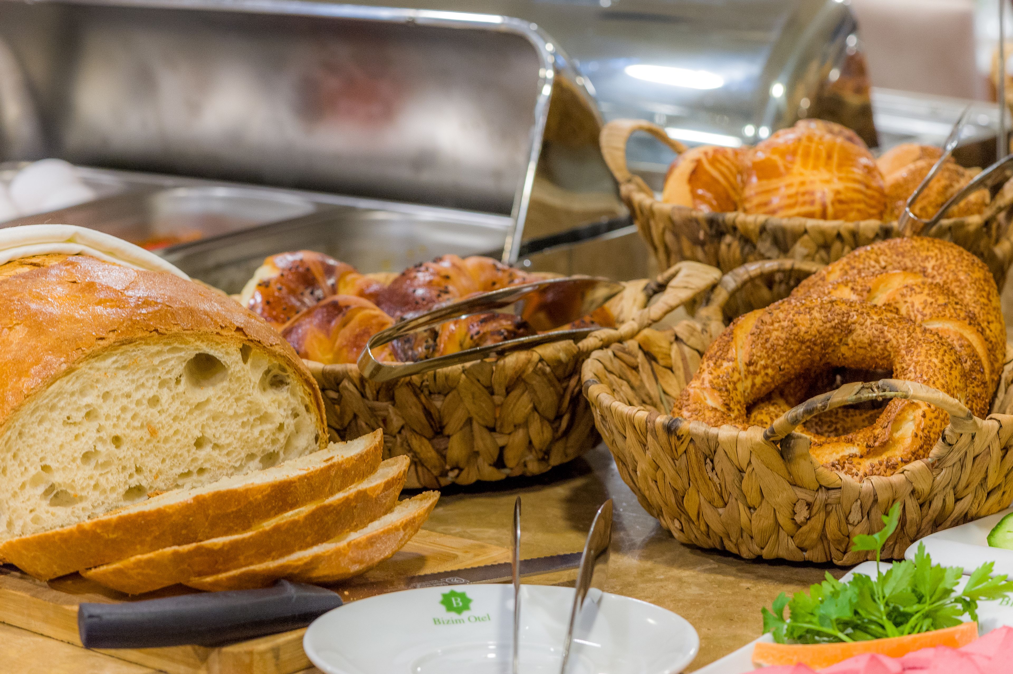 A buffet with various breads and pastries.