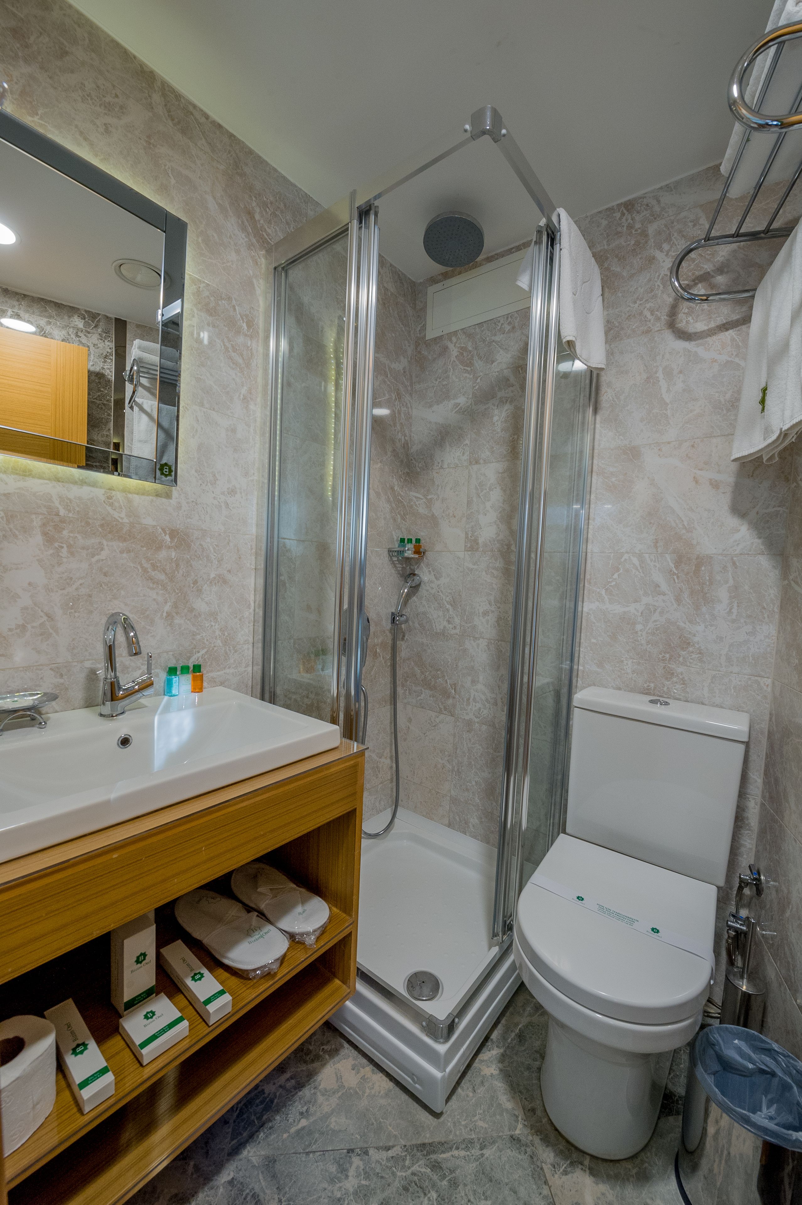 Een badkamer met een douchecabine, een wastafel met toiletartikelen en een toilet.