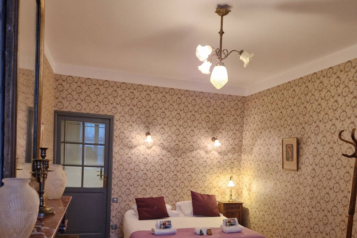 A bedroom with a bed, a dresser, a mirror, and a door.