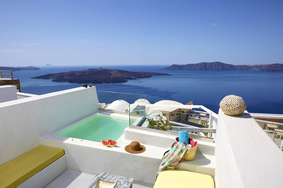 Eine Dachterrasse mit Pool, Sitzbereichen und Blick auf das Meer und die Inseln.