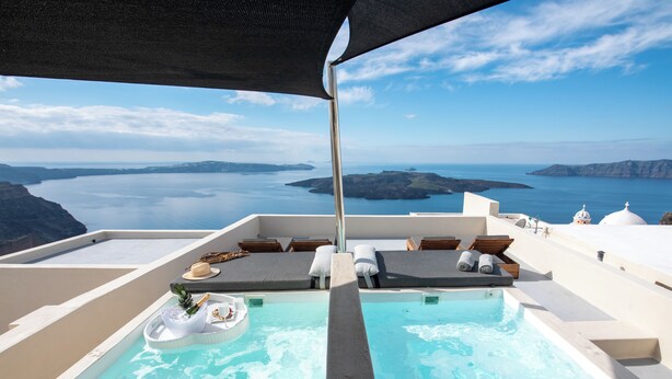A rooftop infinity pool with a view of the sea and islands.