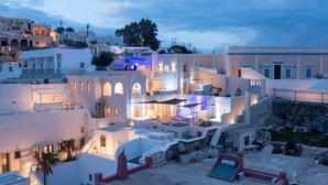 A white building with multiple balconies and a pool area.